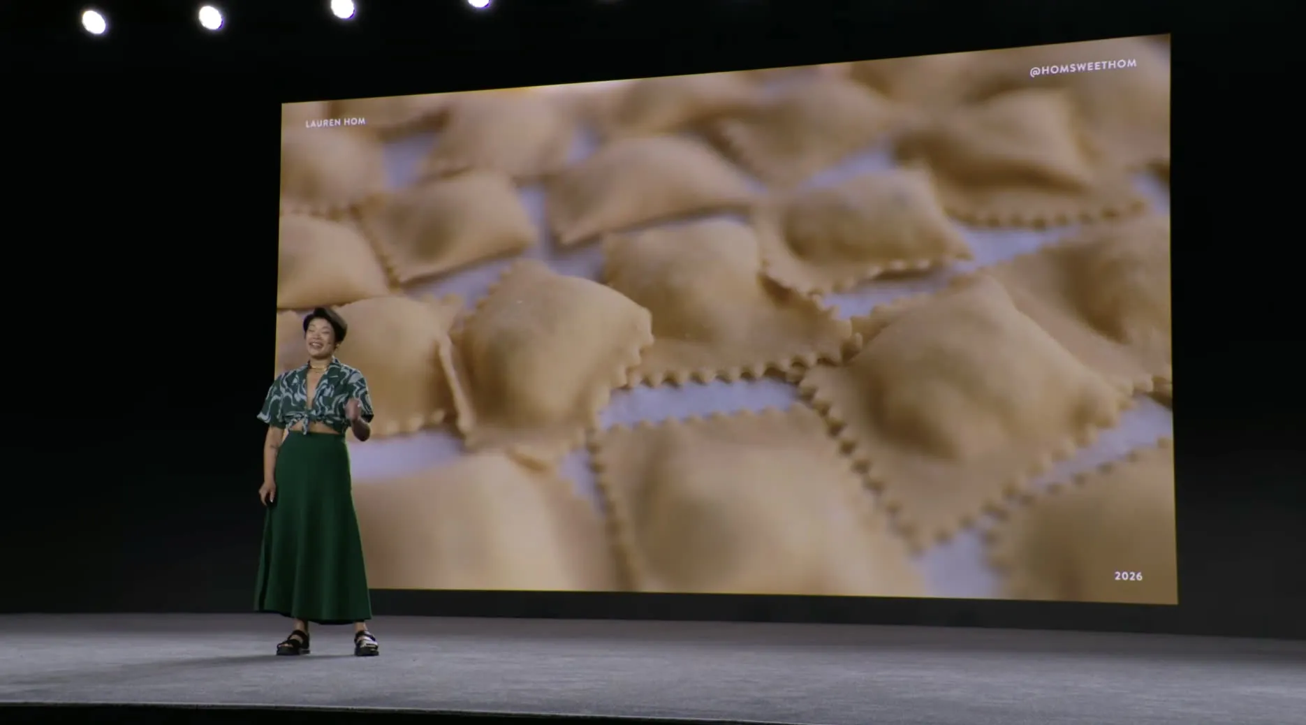Lauren Hom on stage, the screen behind her filled with rows of freshly cut ravioli