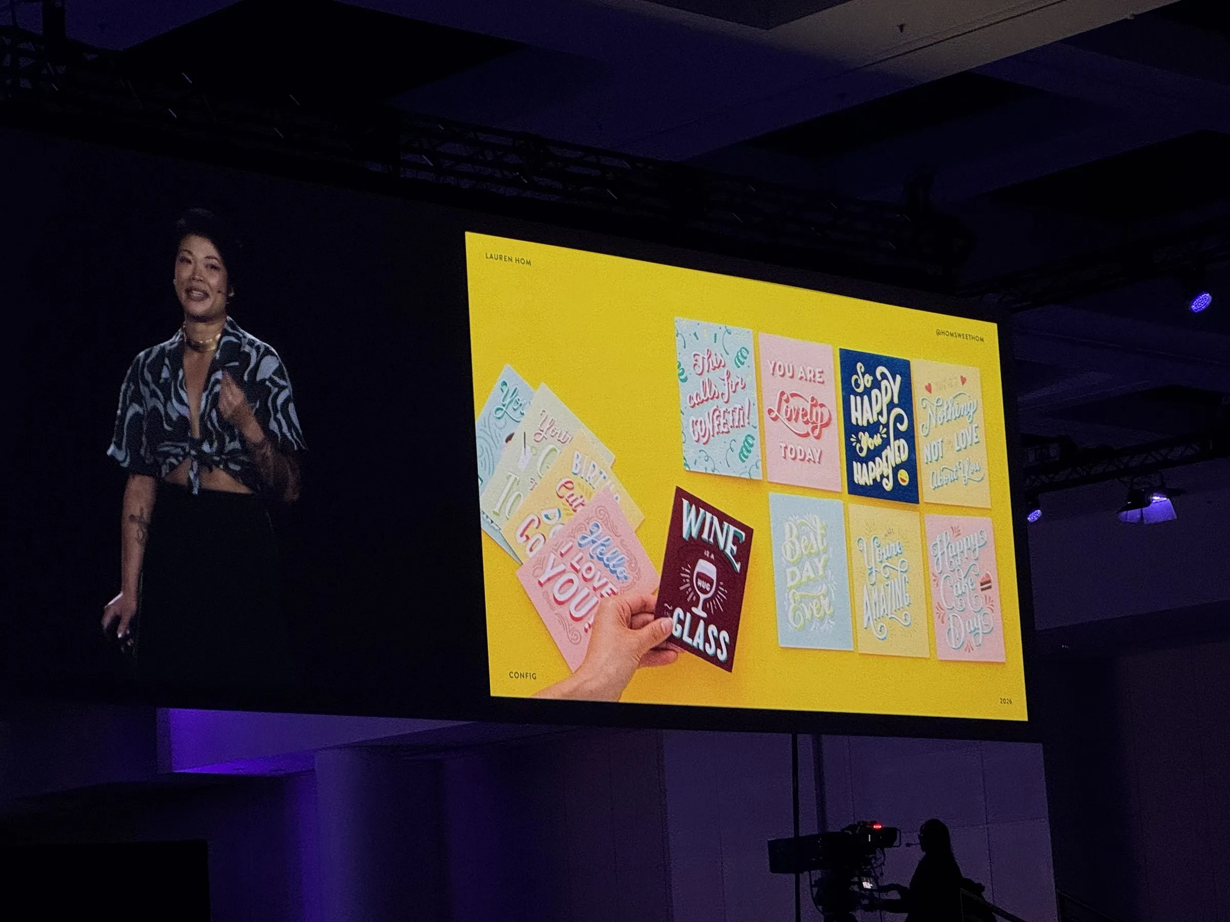 Lauren Hom on stage beside a yellow slide showing a fan of her hand-lettered greeting cards